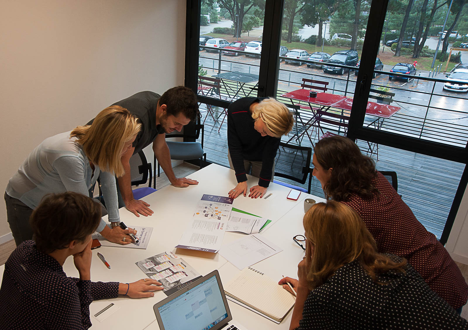 Équipe dans une salle de réunion autour table vue arbres nature travail team discussion bureaux à louer location domiciliation commerciale salle réunion Centre d'affaires lorient mer